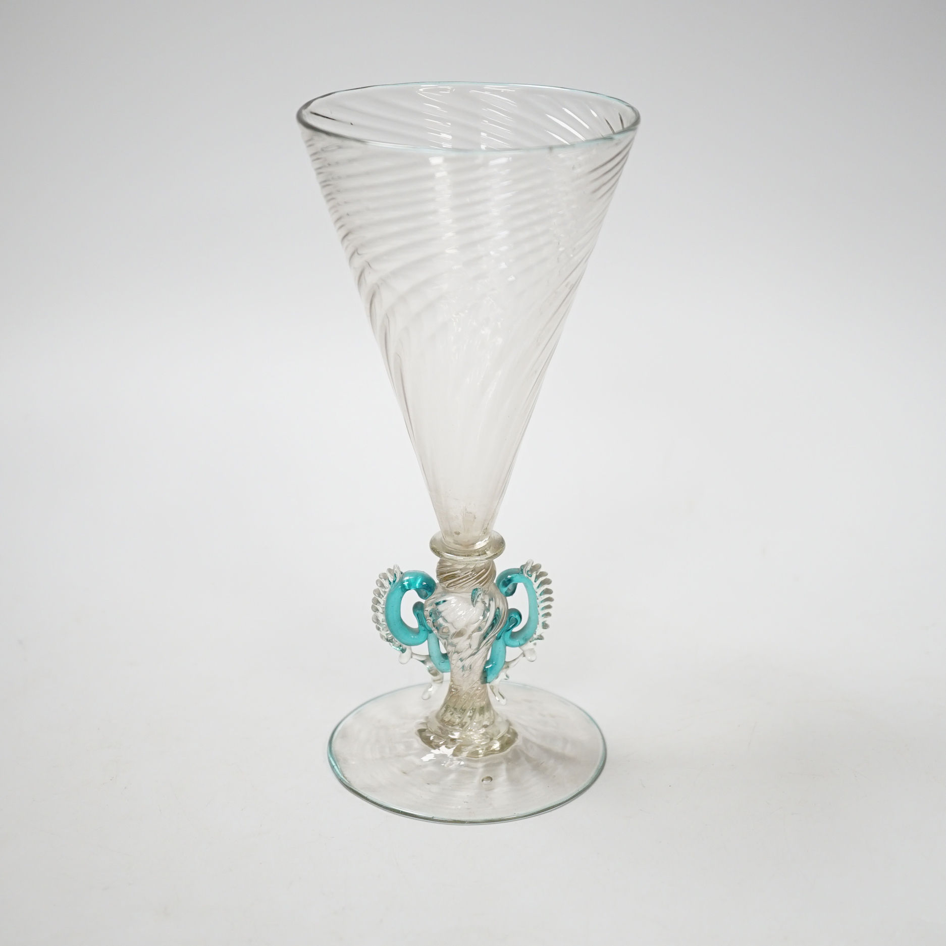 A Facon de Venise wine glass, c.1800, the round funnel bowl is spiral moulded over a blade knop, round knop and inverted baluster with applied turquoise ears, on spiral moulded foot with rough pontil, 16.9cm high